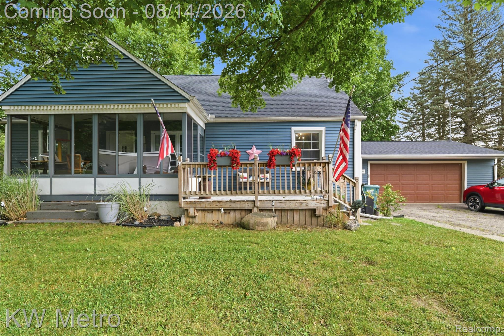 201 South Maple Leaf Road Lapeer, MI 48446 - Photo 49 of 70 Blue siding exterior with an attached garage, screened porch, and a wood-decked front porch