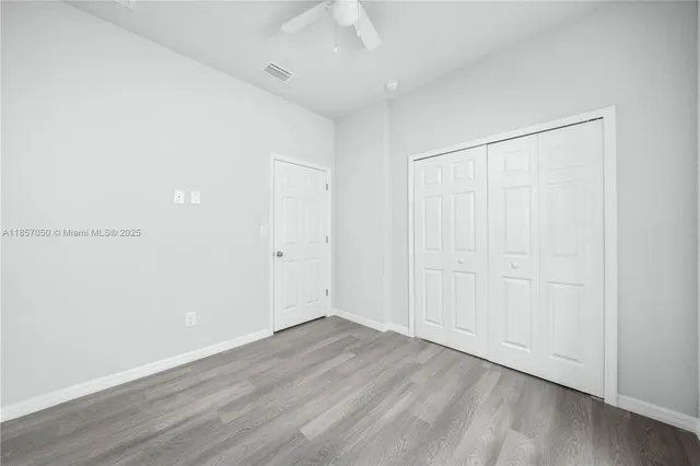 an empty room with wooden floor and closet