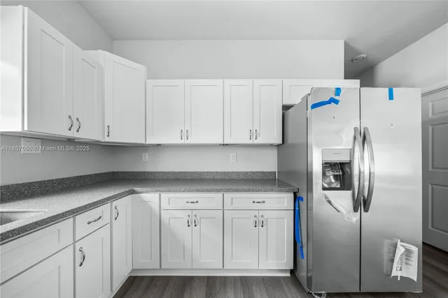 a kitchen with white cabinets and appliances