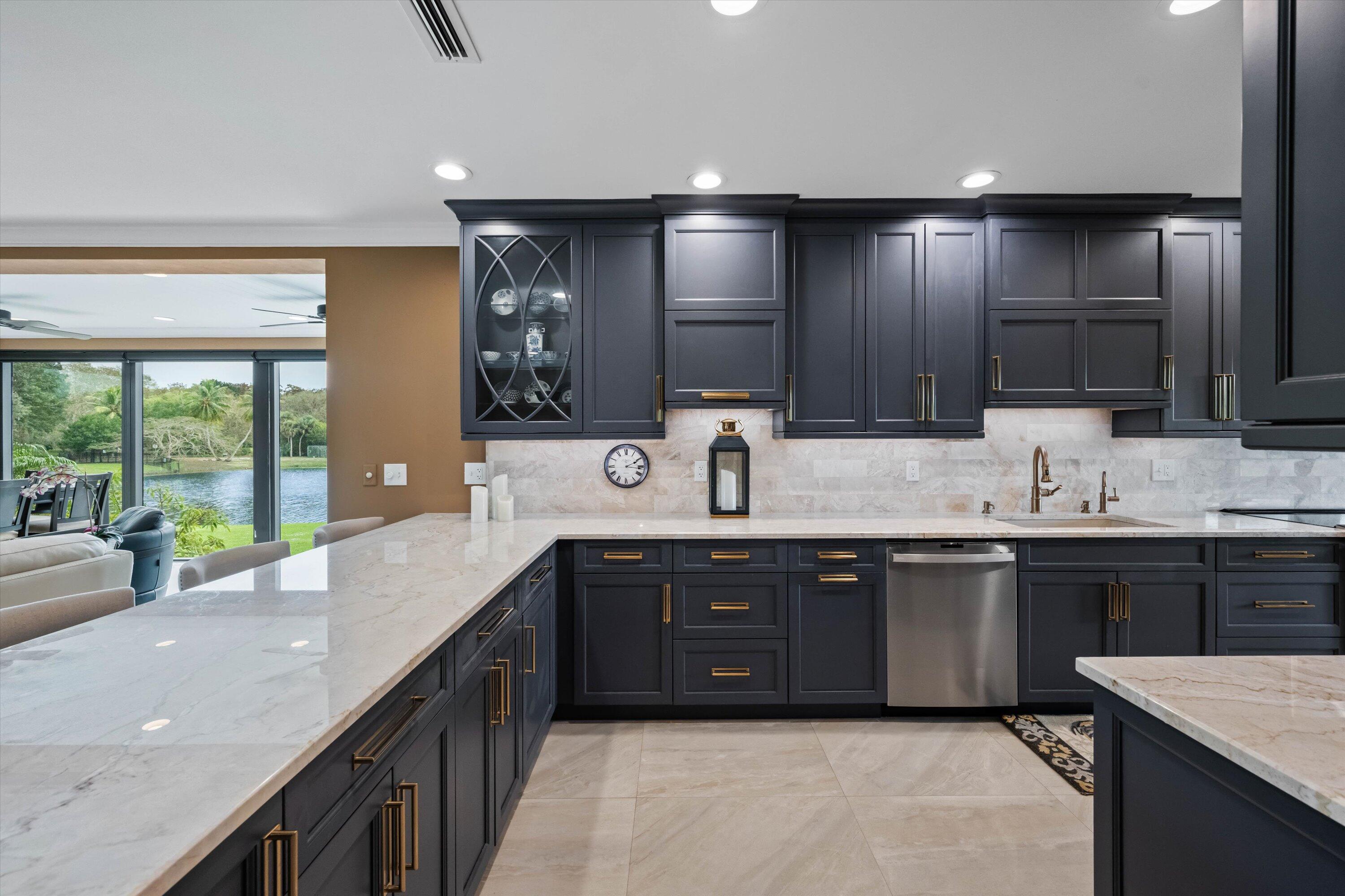 13254 Polo Club Road, Unit C202 Wellington, FL 33414 - Photo 11 of 27 a large kitchen with kitchen island a sink appliances and a large window