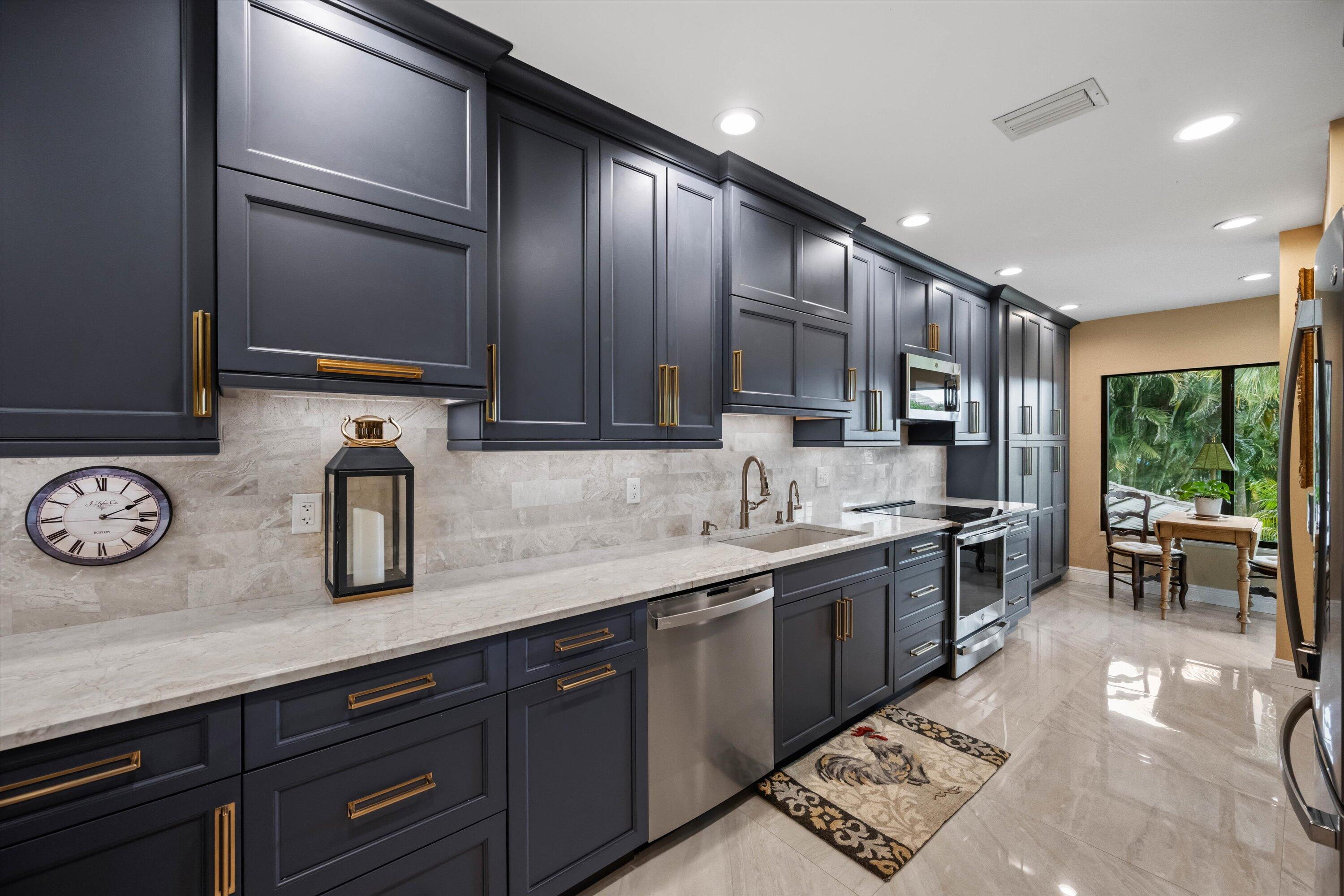 13254 Polo Club Road, Unit C202 Wellington, FL 33414 - Photo 12 of 27 a kitchen with stainless steel appliances granite countertop a sink stove and cabinets