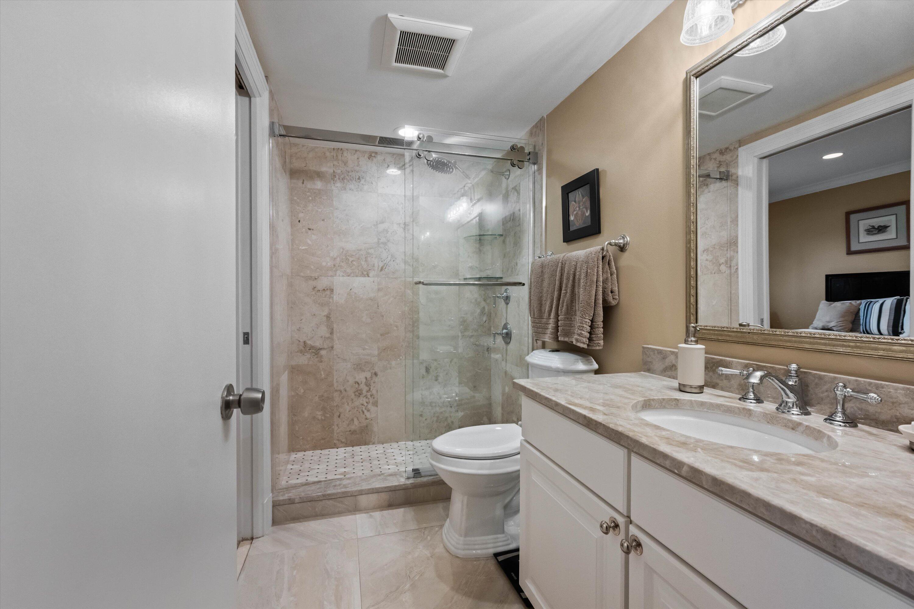 13254 Polo Club Road, Unit C202 Wellington, FL 33414 - Photo 19 of 27 a bathroom with a granite countertop sink a toilet a mirror and shower