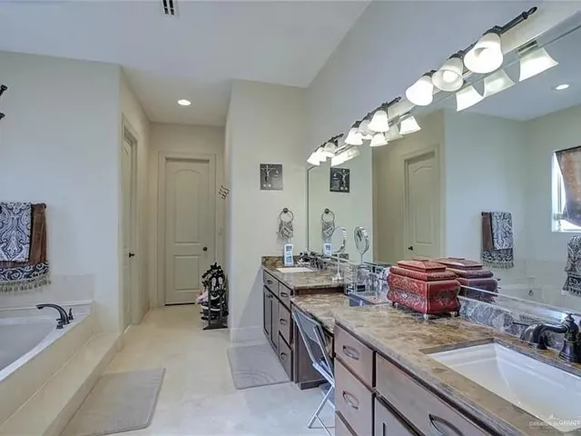 a spacious bathroom with a granite countertop sink and a mirror