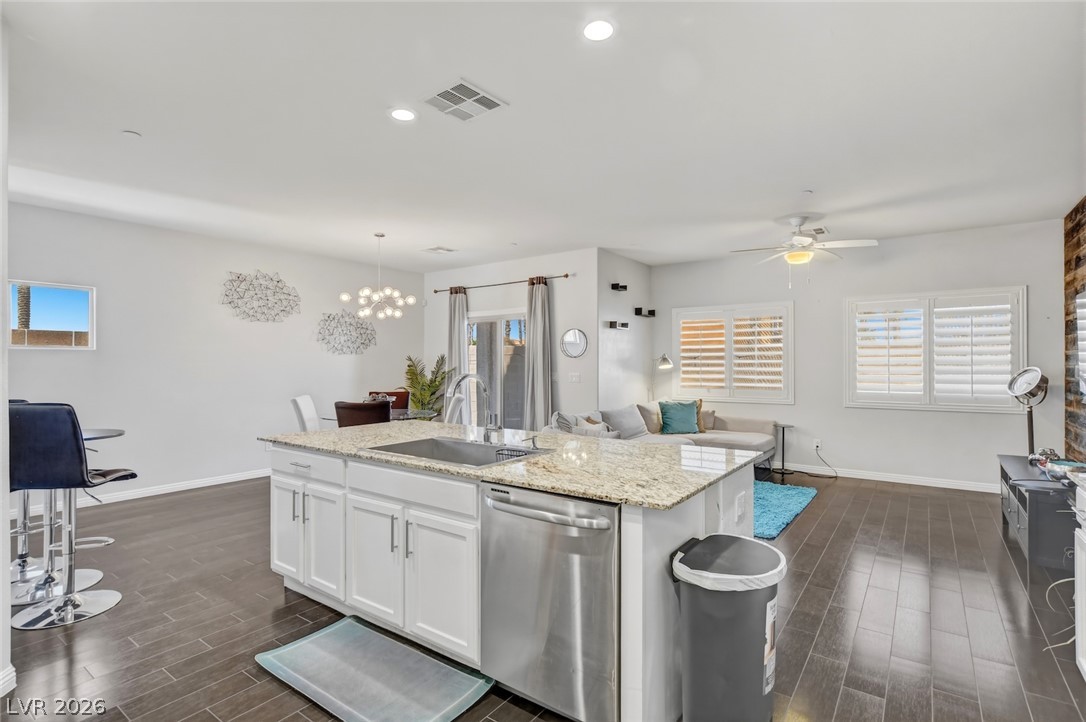 48 Jasmine Point Street Henderson, NV 89074 - Photo 62 of 62 A contemporary open floor plan features a spacious kitchen island and a well-lit living area.