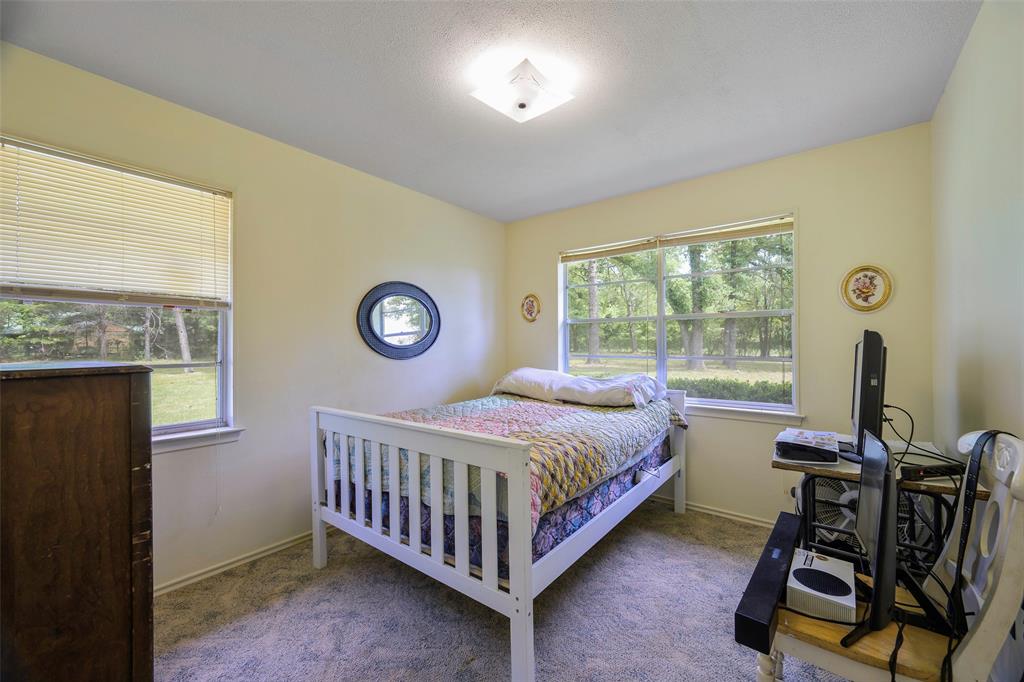 1113 West Will White Road Kemp, TX 75143 - Photo 13 of 22 a bedroom with a bed and a desk next to a window