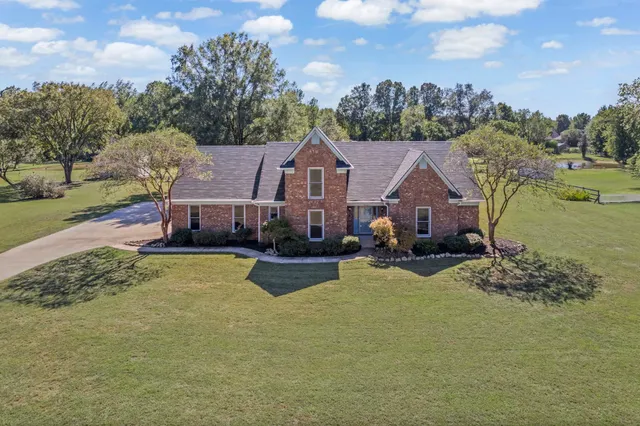 a view of a house with a big yard and large trees