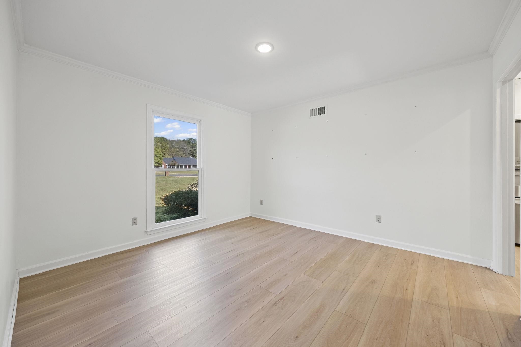 10661 Chapel Hill Road Lakeland, TN 38002 - Photo 14 of 40 a view of an empty room with wooden floor and a window