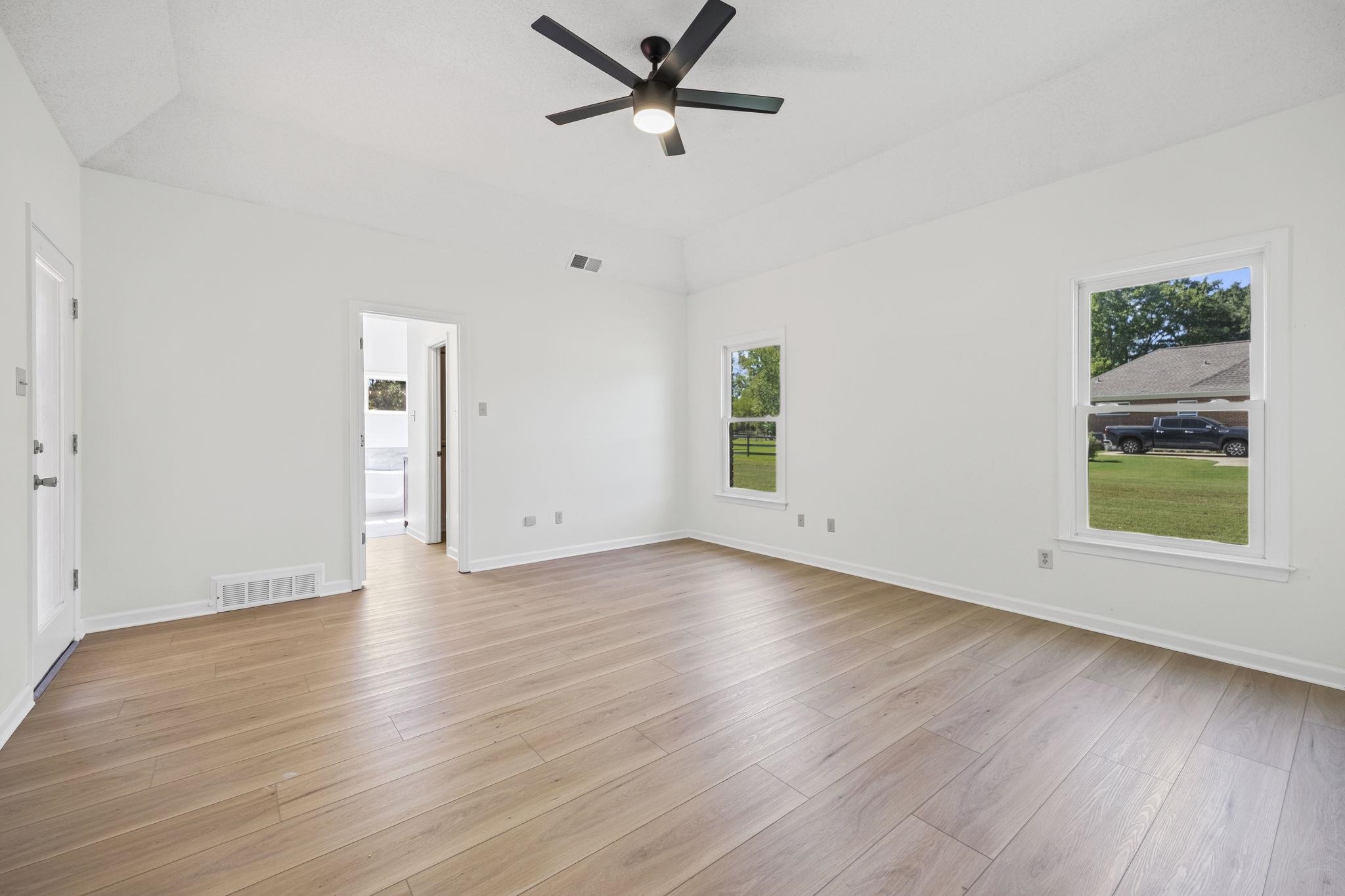 10661 Chapel Hill Road Lakeland, TN 38002 - Photo 26 of 40 an empty room with wooden floor a ceiling fan and windows