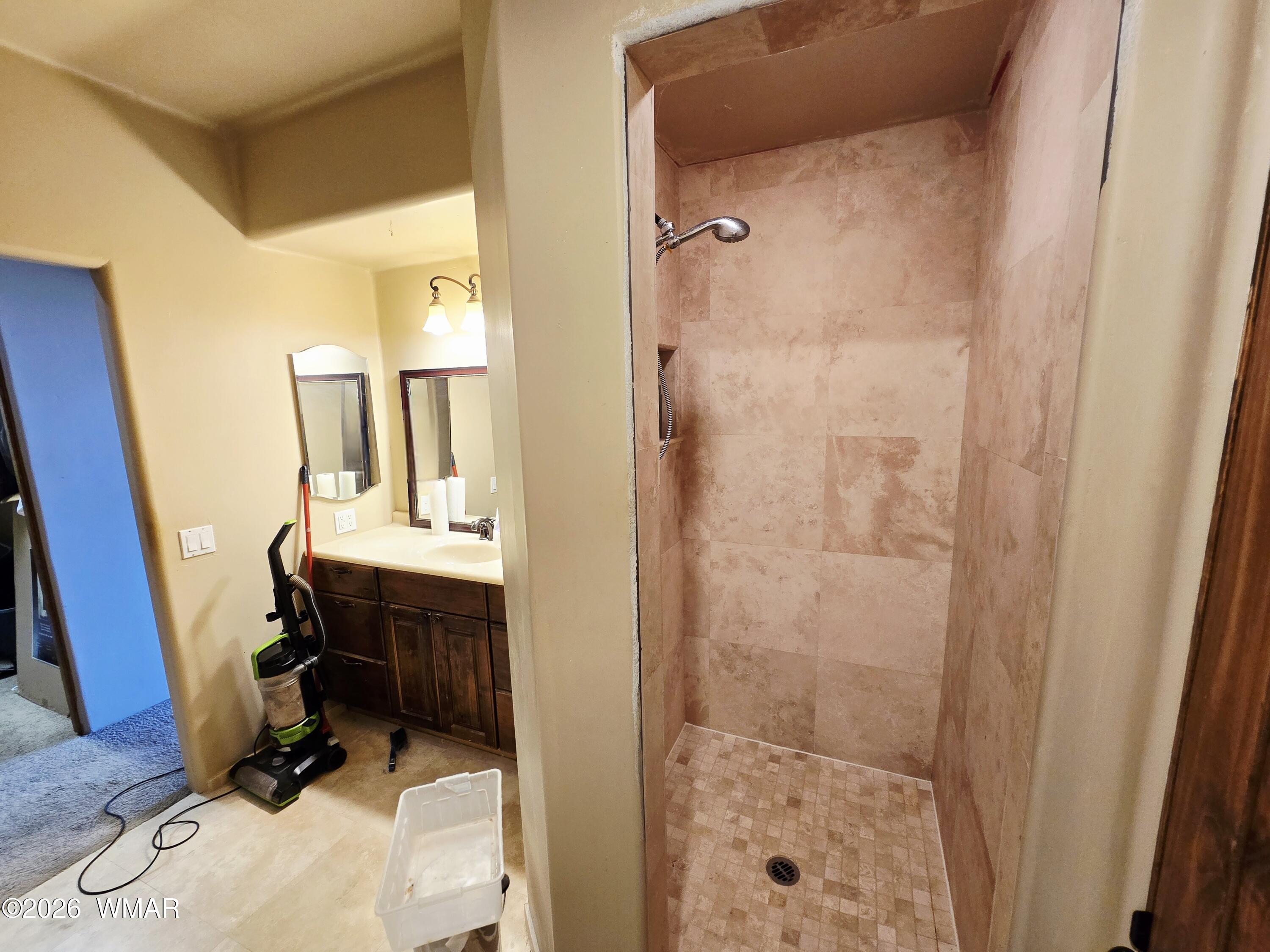 9046 Miller Trail Snowflake, AZ 85937 - Photo 14 of 34 a bathroom with a sink a mirror a vanity and shower