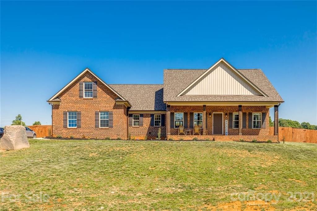 5809 Sikes Mill Road Monroe, NC 28110 - Photo 1 of 32 a front view of a house with large windows and a yard