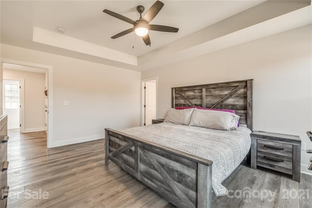 5809 Sikes Mill Road Monroe, NC 28110 - Photo 19 of 32 a bedroom with a bed and a chandelier