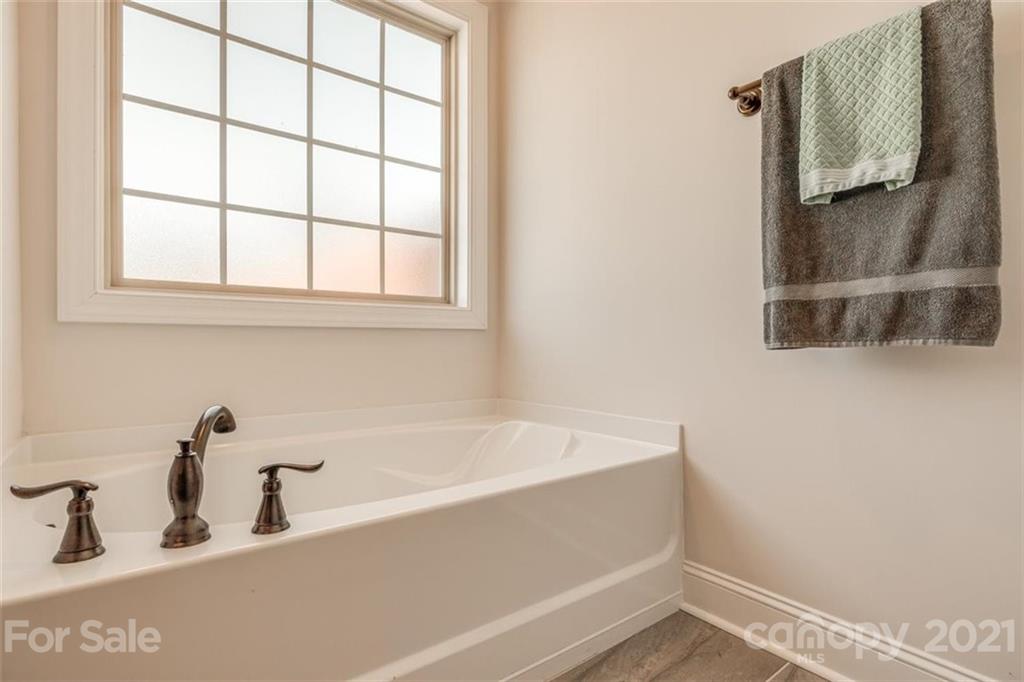 5809 Sikes Mill Road Monroe, NC 28110 - Photo 22 of 32 a bathroom with a bathtub and mirror