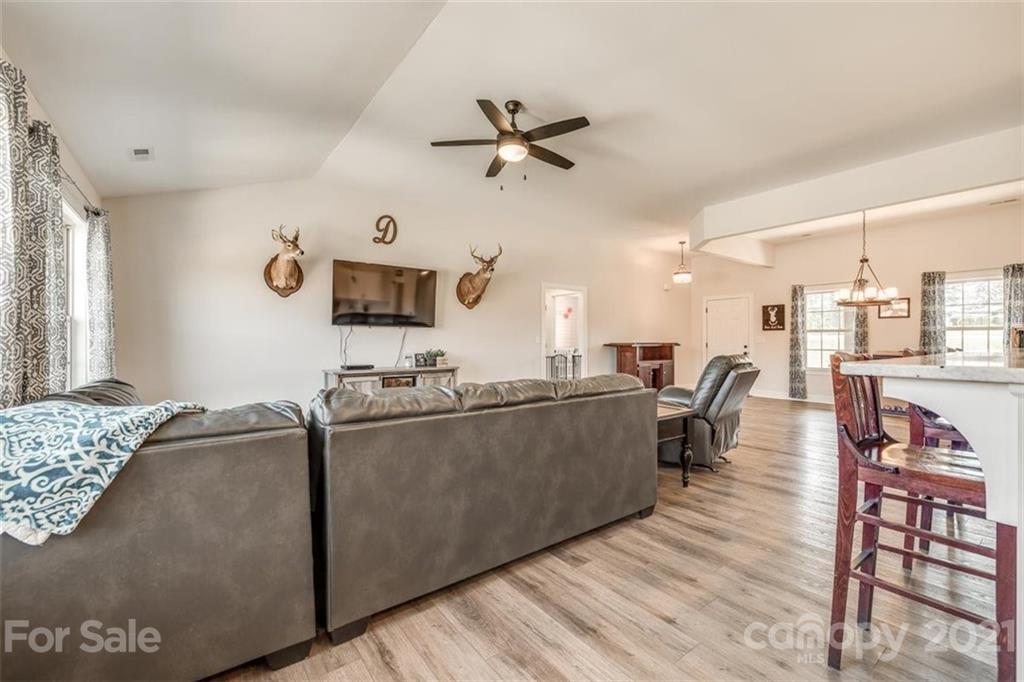 5809 Sikes Mill Road Monroe, NC 28110 - Photo 7 of 32 a living room with furniture a flat screen tv and a ceiling fan