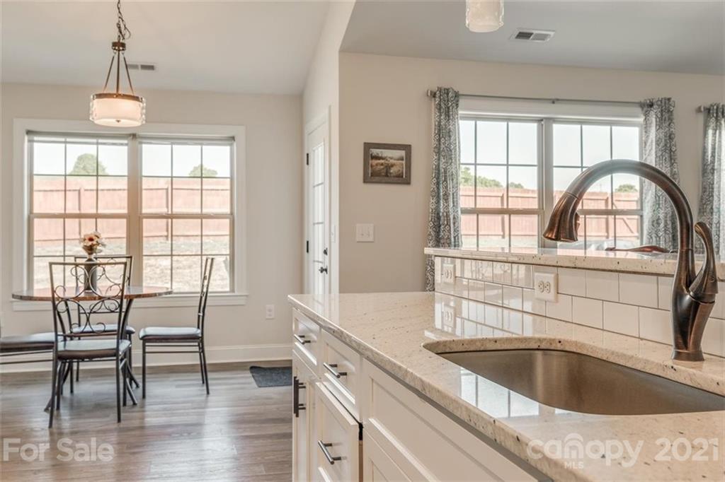 5809 Sikes Mill Road Monroe, NC 28110 - Photo 10 of 32 a view of a kitchen area with furniture and wooden floor