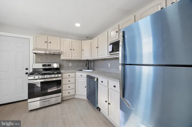 a kitchen with cabinets stainless steel appliances and counter space