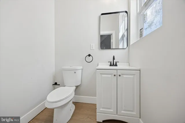 a bathroom with a toilet a sink and mirror