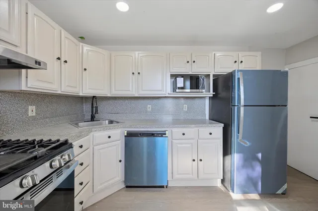 a kitchen with cabinets appliances and a counter