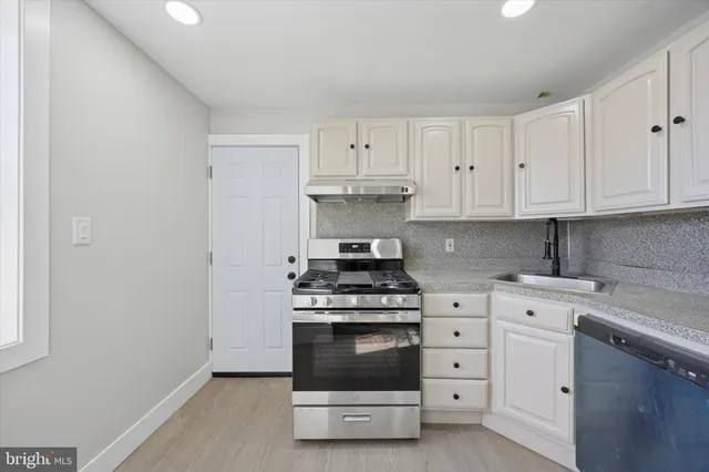 a kitchen with white cabinets and stainless steel appliances