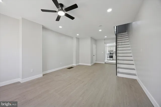 an empty room with windows and ceiling fan