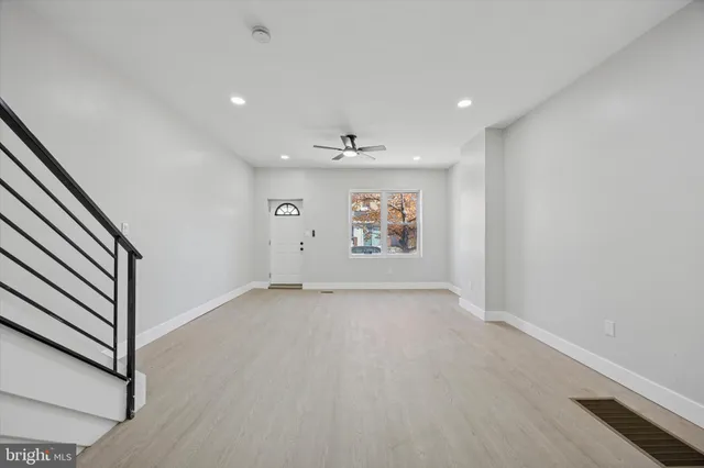 an empty room with windows and ceiling fan