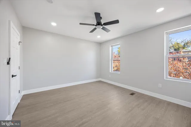 an empty room with window and ceiling fan