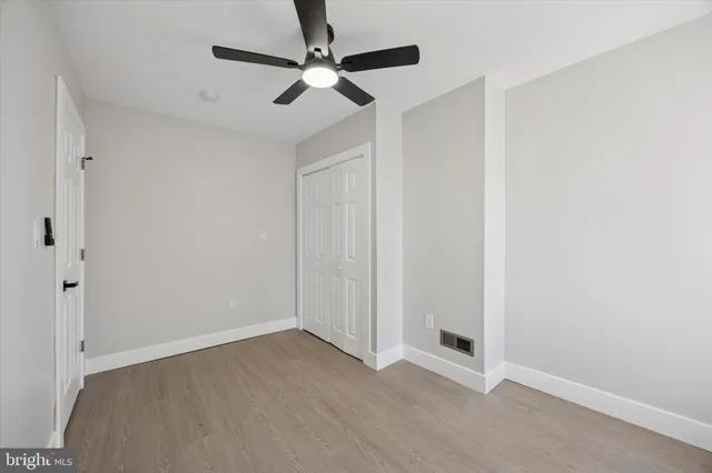 an empty room with a ceiling fan and carpet
