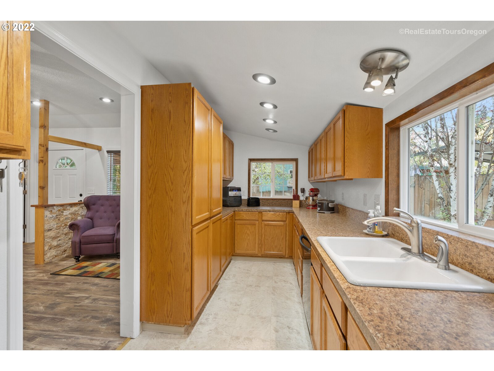 707 Roxe Drive Forest Grove, OR 97116 - Photo 7 of 32 a kitchen with kitchen island granite countertop a sink cabinets and refrigerator
