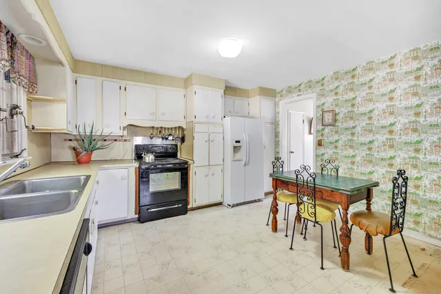 a kitchen with granite countertop cabinets and chairs