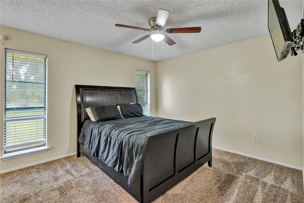 108 Prairie Creek Road Red Oak, TX 75154 - Photo 12 of 19 Carpeted room featuring a ceiling fan with integrated lighting, two windows with horizontal blinds, and neutral wall tones