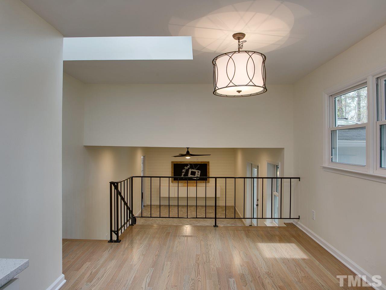 1909 Fountain Ridge Road Chapel Hill, NC 27517 - Photo 9 of 25 a view of a hallway with wooden floor and a chandelier