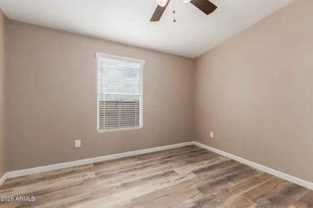 an empty room with a window and a fan