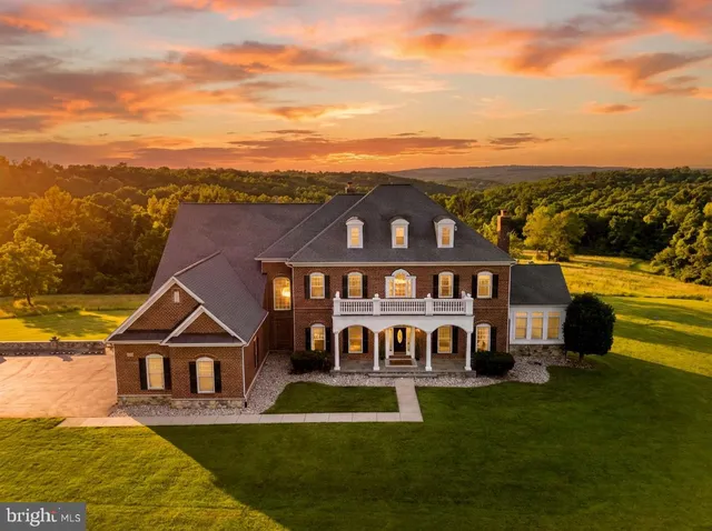 a view of a big house with a big yard and large trees