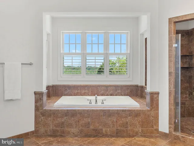 a bedroom with a bed and large windows