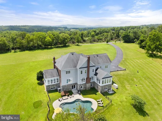 an aerial view of a house with swimming pool garden and mountain view