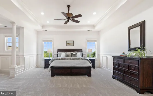 a spacious bedroom with a bed a dresser and potted plant