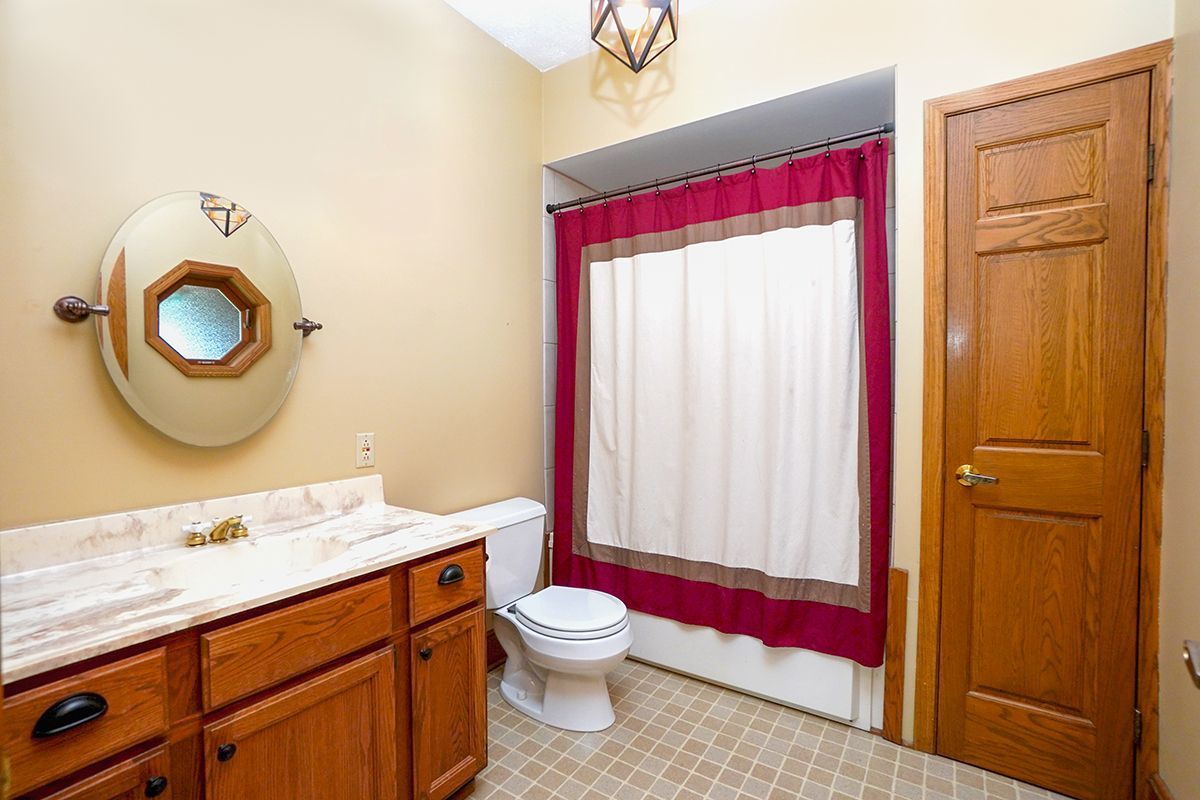 10057 Cherry Valley Road Genoa, IL 60135 - Photo 13 of 32 a bathroom with a sink a toilet and shower curtain