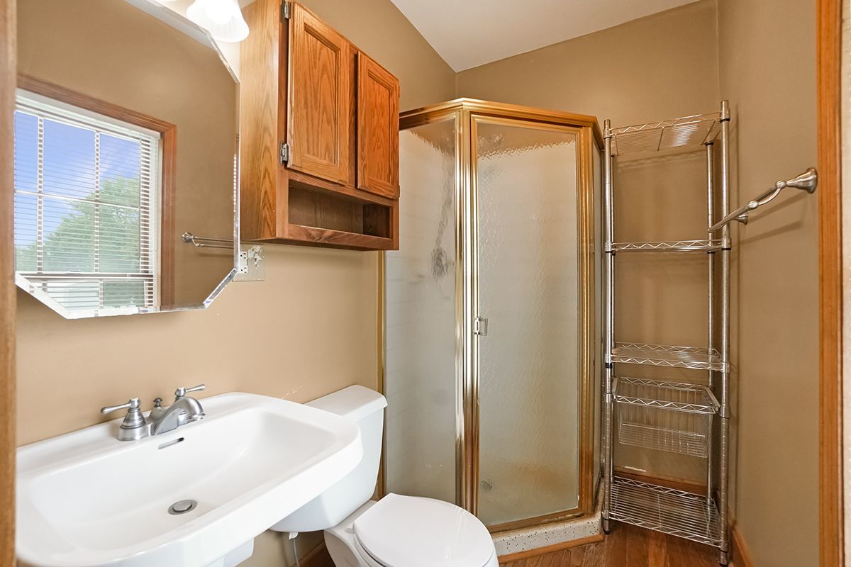 10057 Cherry Valley Road Genoa, IL 60135 - Photo 19 of 32 a bathroom with a sink a toilet and shower
