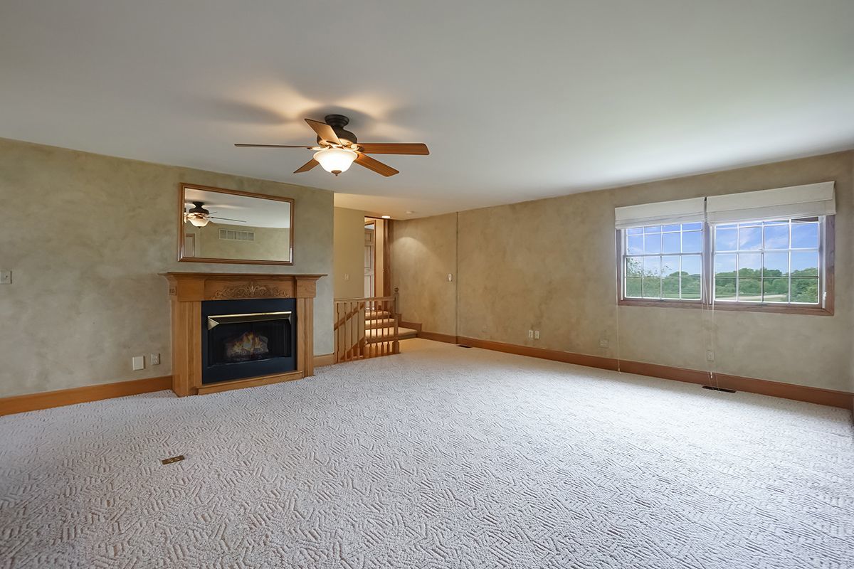 10057 Cherry Valley Road Genoa, IL 60135 - Photo 23 of 32 an empty room with windows and fireplace