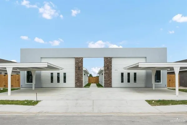 a view of a white house with basketball court