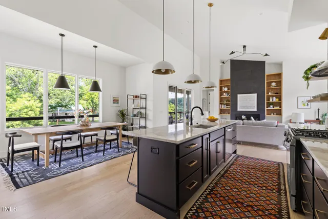 a kitchen with stainless steel appliances granite countertop a stove a sink dishwasher and a flat tv screen