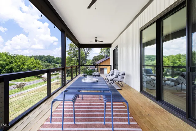 a view of a balcony with chairs and wooden floor