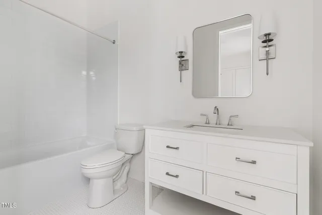 a bathroom with a granite countertop toilet sink mirror and vanity