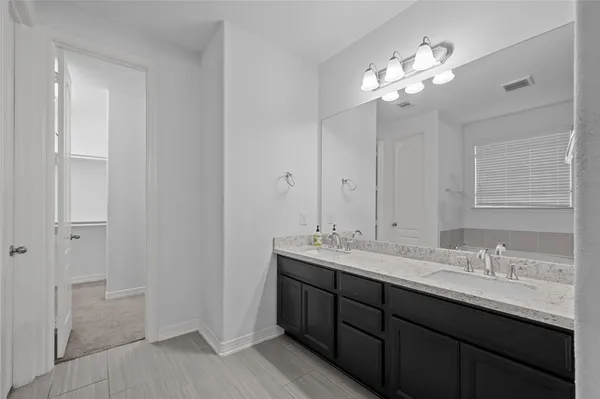 a bathroom with a double vanity sink and a mirror