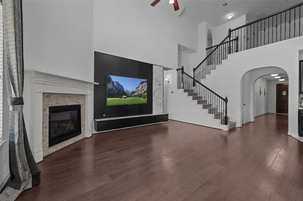 a view of an empty room with wooden floor fireplace and a window