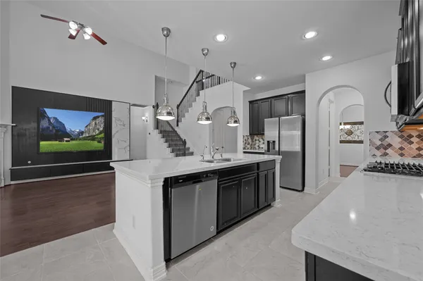 a large kitchen with stainless steel appliances a large counter top