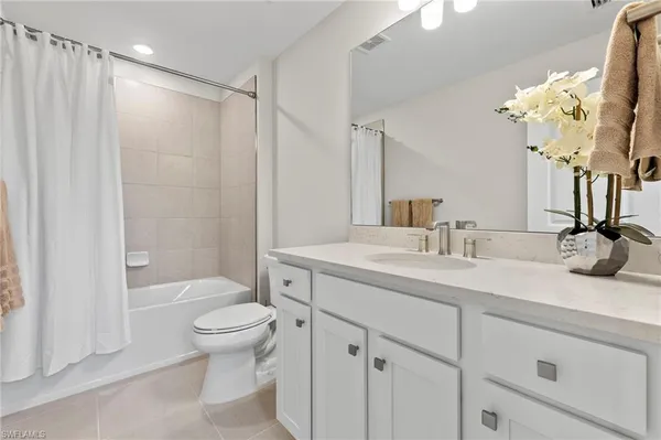 a bathroom with a sink a toilet and a large mirror