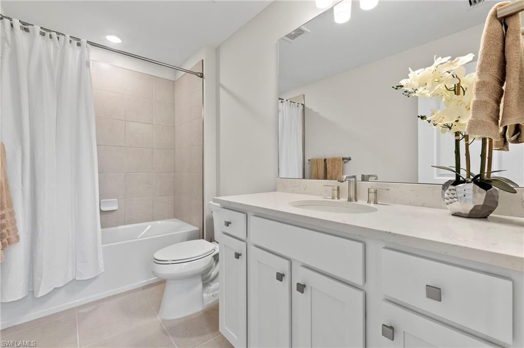 2147 Yellowfin Circle Naples, FL 34114 - Photo 16 of 34 a bathroom with a sink a toilet and a large mirror