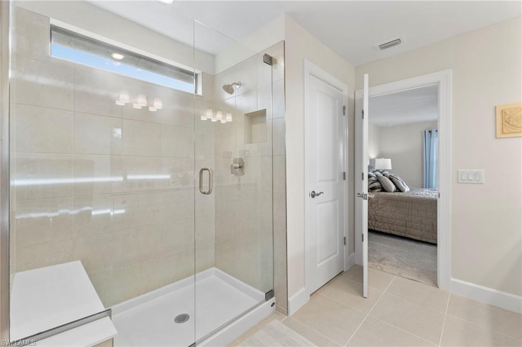2147 Yellowfin Circle Naples, FL 34114 - Photo 20 of 34 a en suite bathroom with a glass shower door and a bathroom