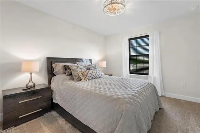 a large bed sitting in a bedroom next to a lamp