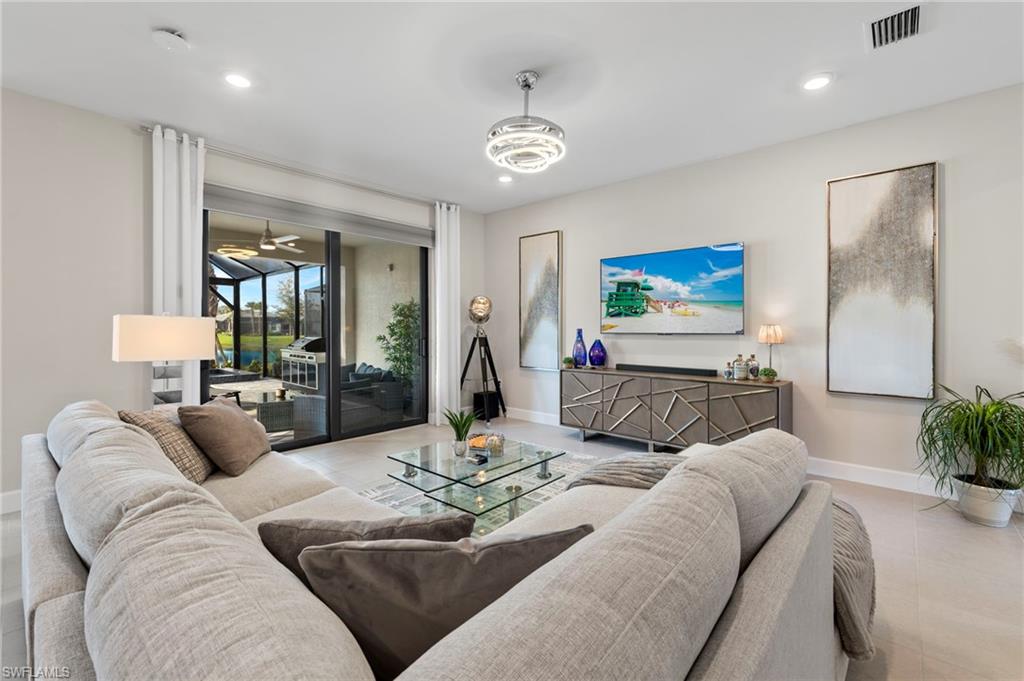 2147 Yellowfin Circle Naples, FL 34114 - Photo 4 of 34 a living room with furniture and a chandelier